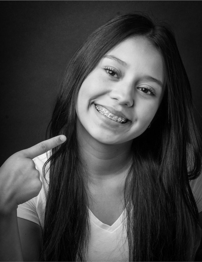 Teen pointing at her braces