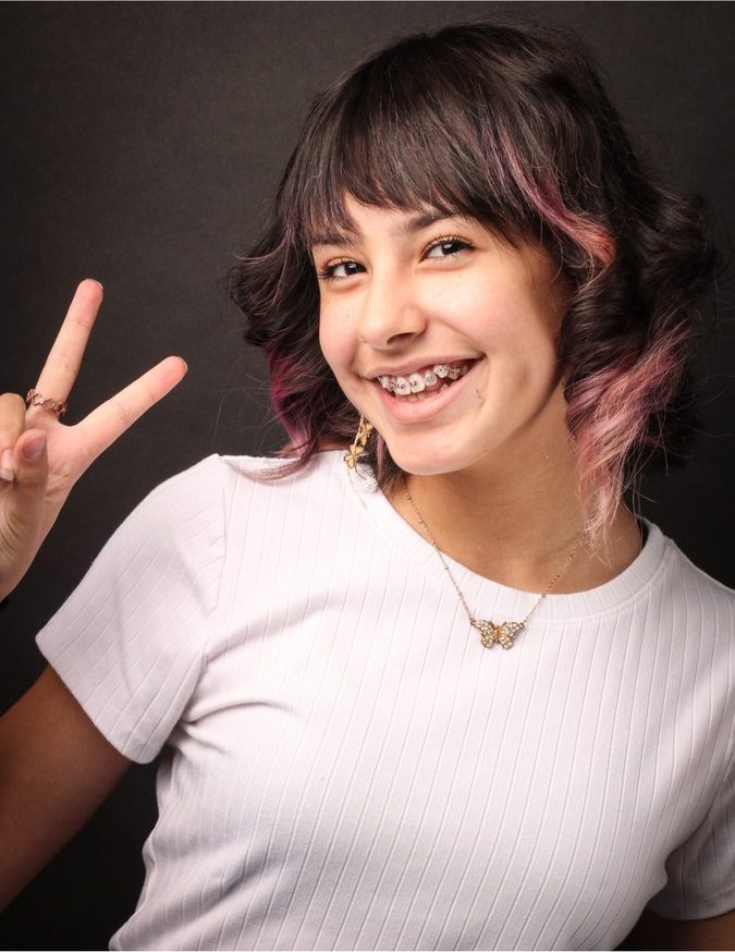 Teen with braces and a peace sign
