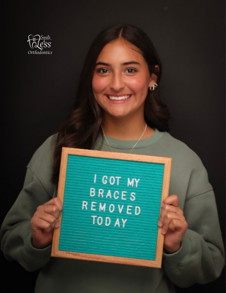 Patient holding a braces removed sign