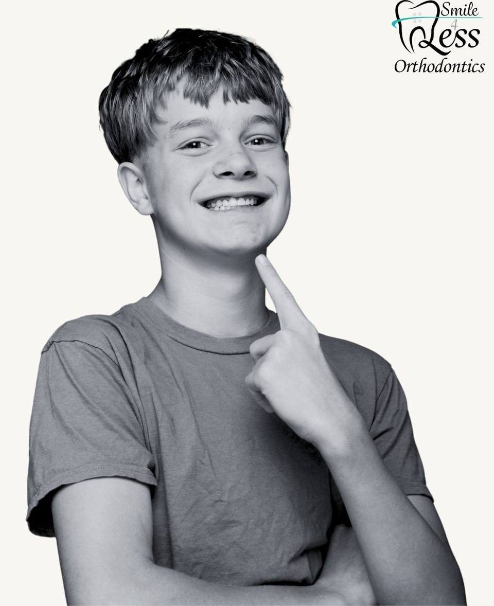 Preteen boy pointing at his braces